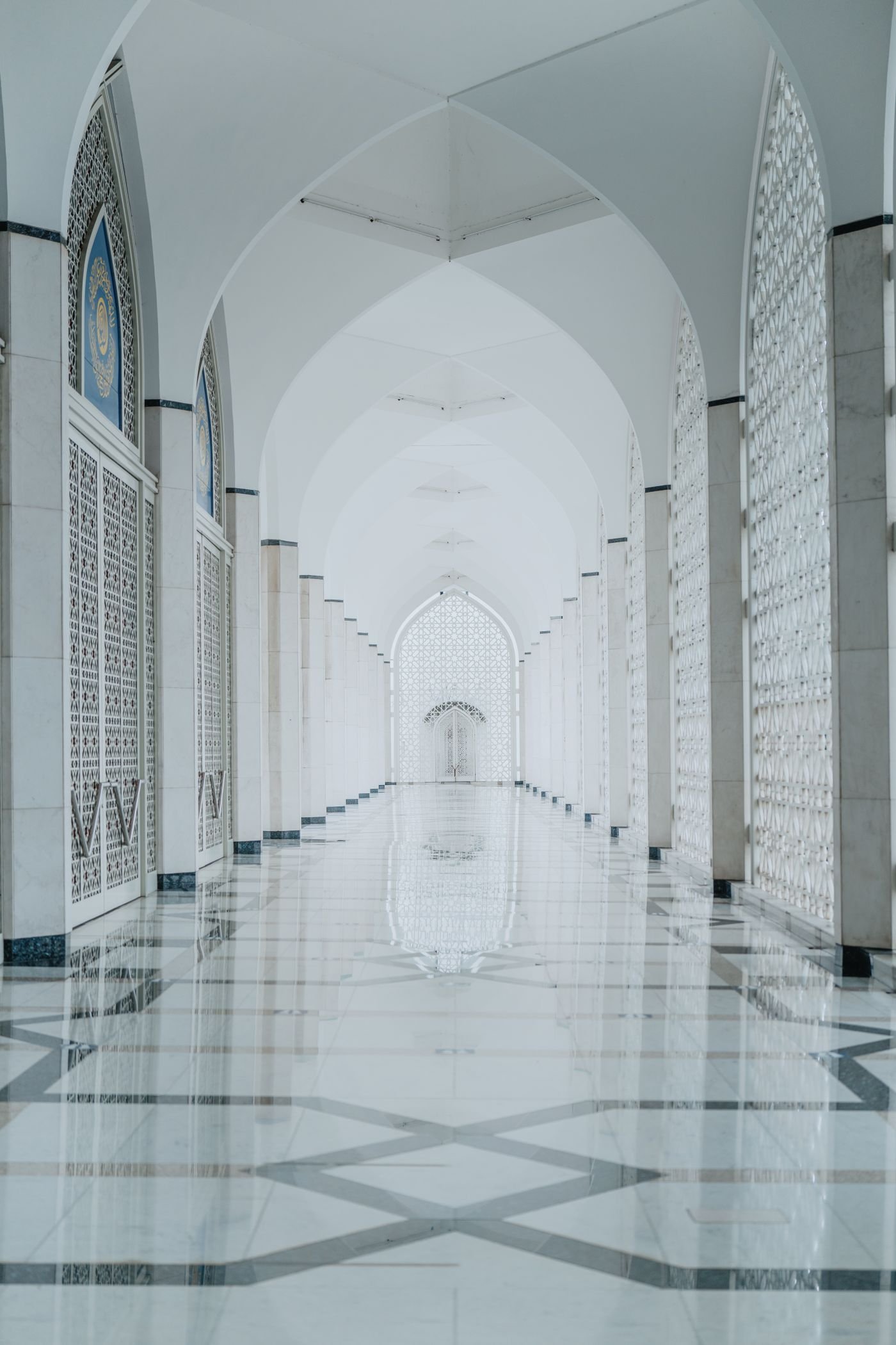 Islamic arched hallway with ornamental architecture and tiled flooring