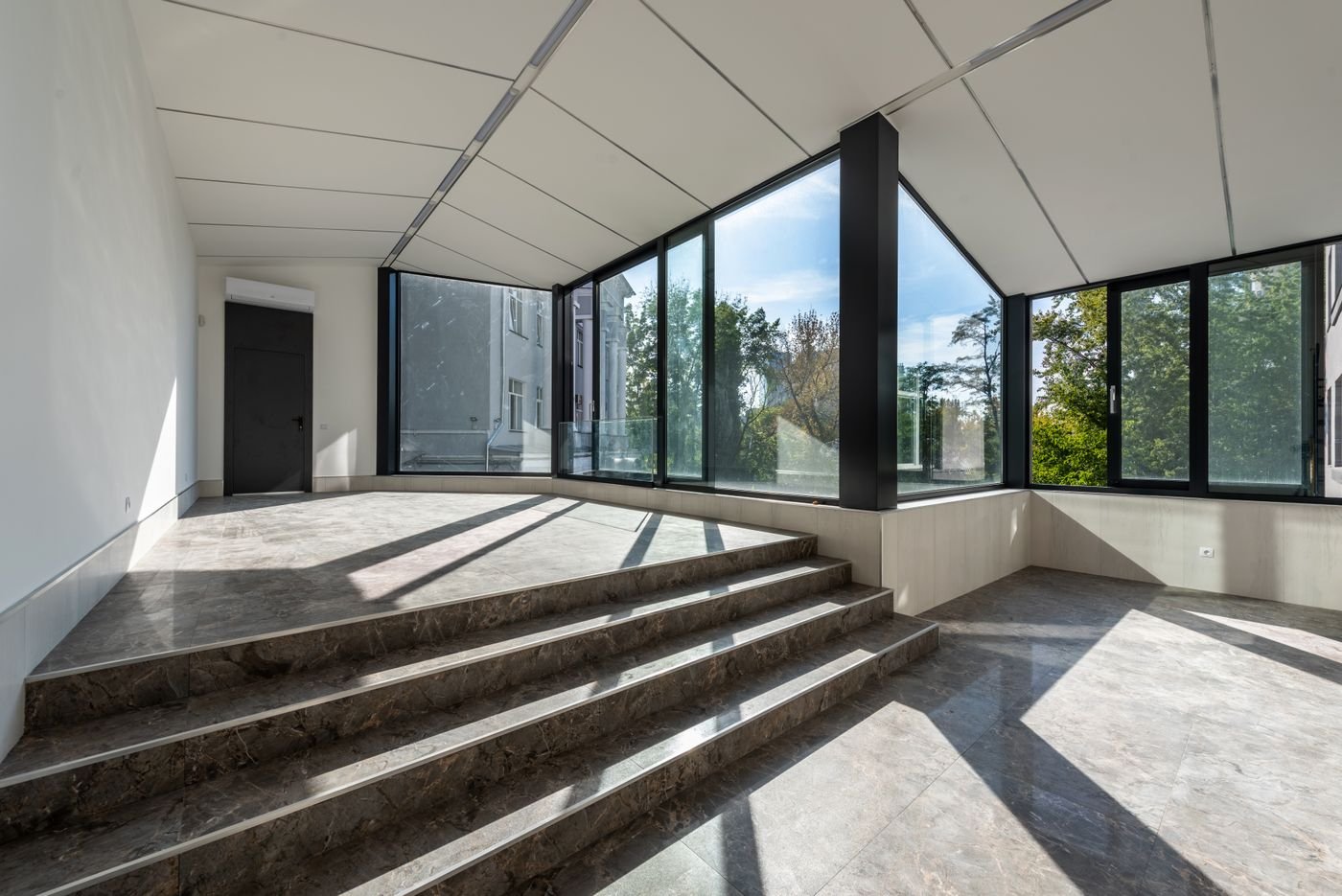 Bright modern room with marble-effect flooring and large windows